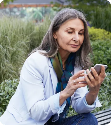 A woman on a park bench looking at her phone.