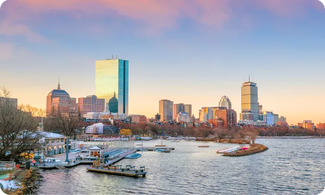 The Boston skyline across the Charles River at dusk.