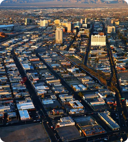 An aerial view of a city's downtown and the blocks around it at sunset.