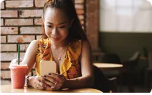 A woman browsing on her phone in a cafe.