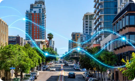 A sunny city street lined with palm trees, with glowing lines of data over it.