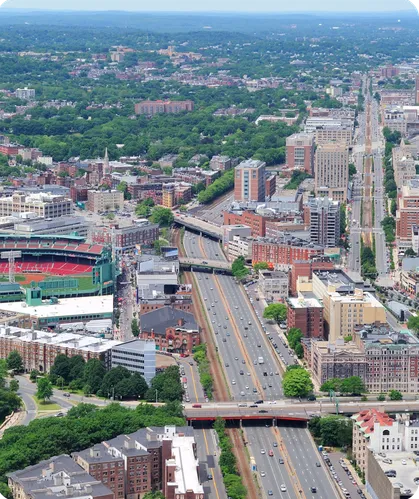 A city of brick neighborhoods and a ballpark seen from above.