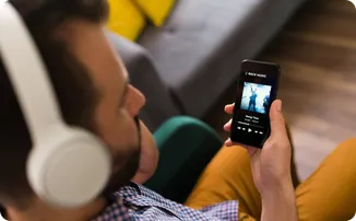 A man listening to music on his phone with headphones.