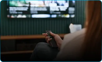A woman holding a remote in front of a television.