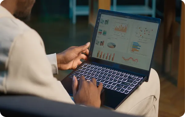 A person reviewing charts on a laptop.